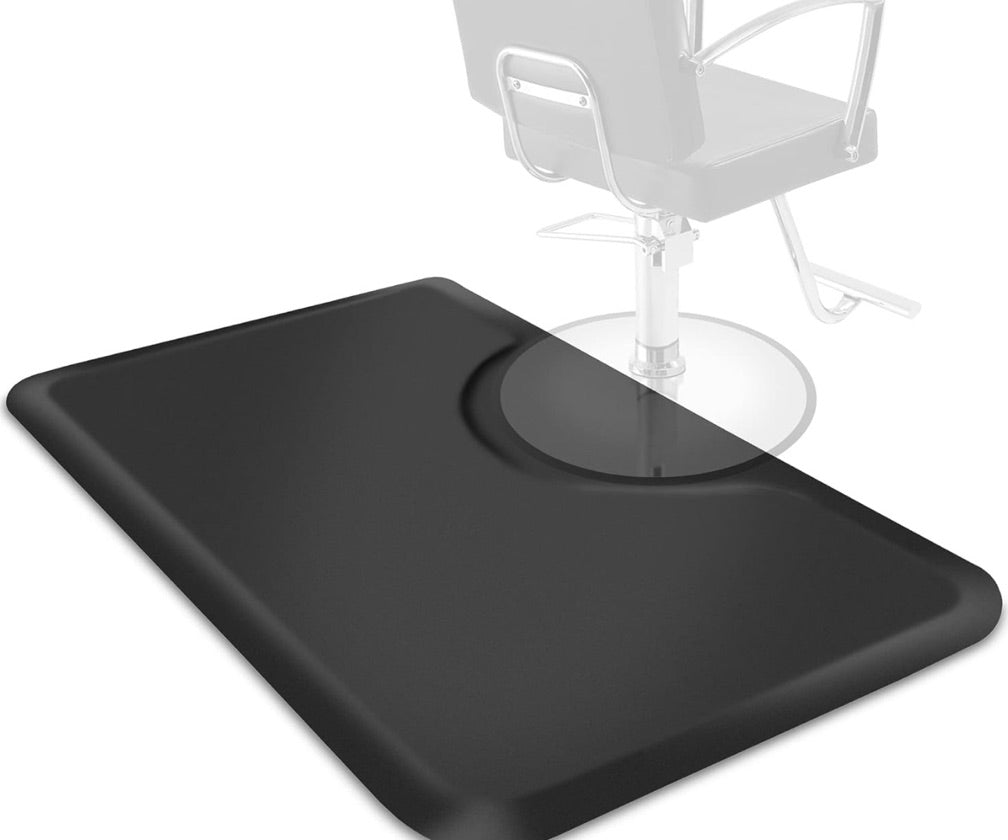 A rectangular, black anti-fatigue floor mat placed under a salon barber chair.