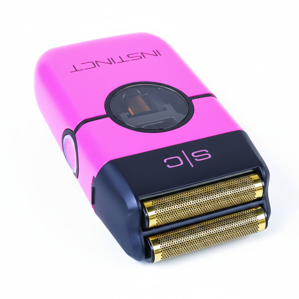 Pink and blue electric shaver with 'Instinct' branding on a beige surface